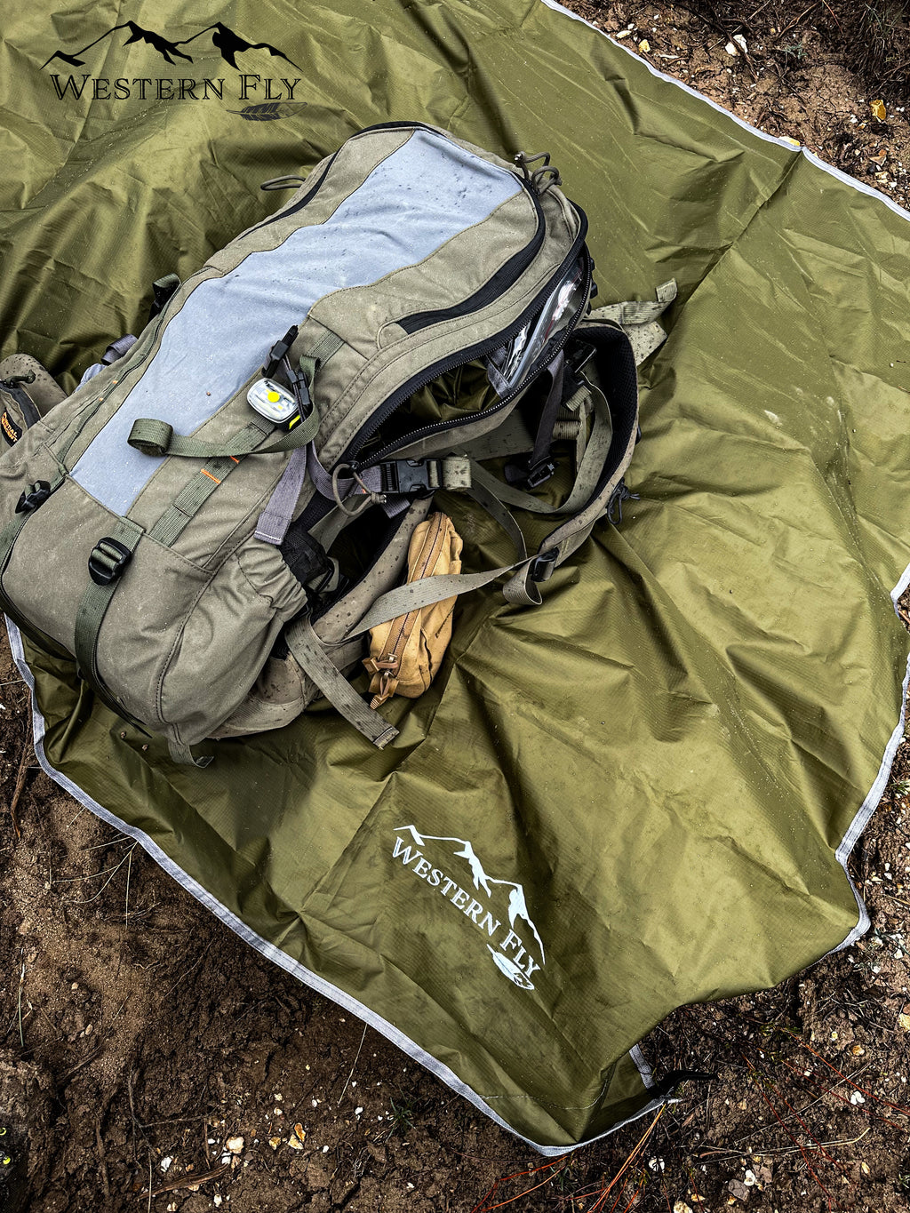 A Western Fly tent fly with a backpack and ground cover laid on top of it.